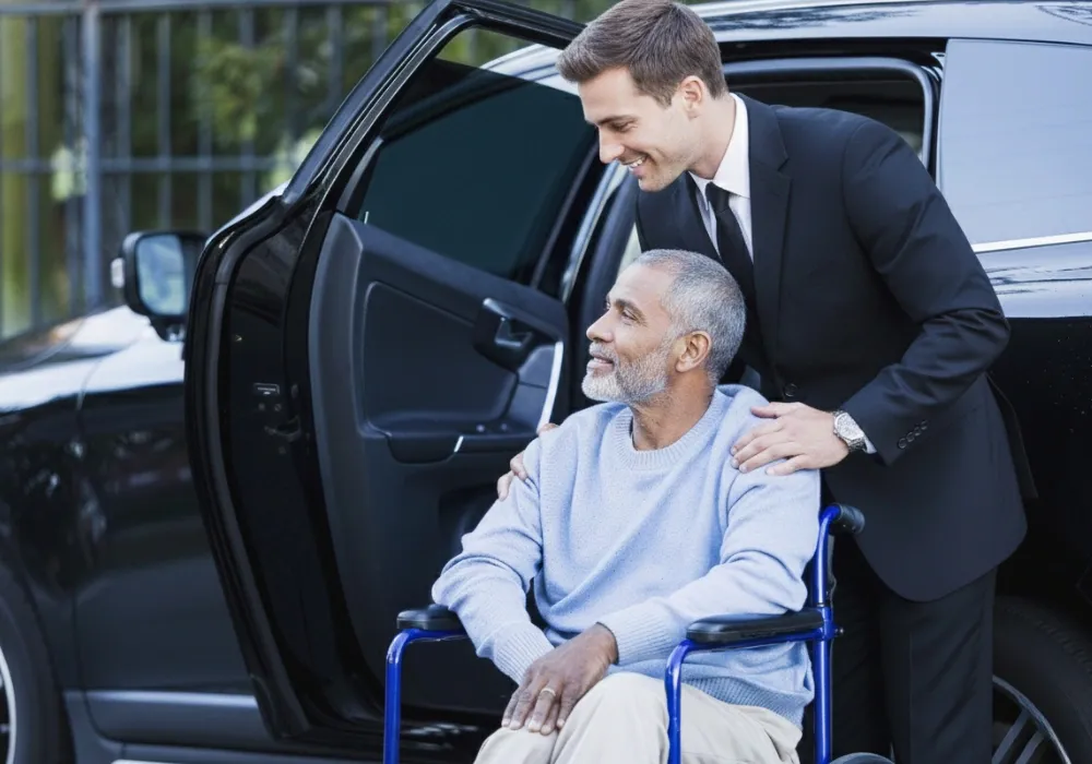 Chauffeur assisting a patient into a luxury vehicle for a medical transfer